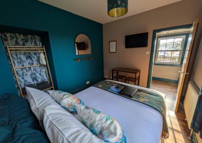 Bedroom with TV, mirror, and hanging space