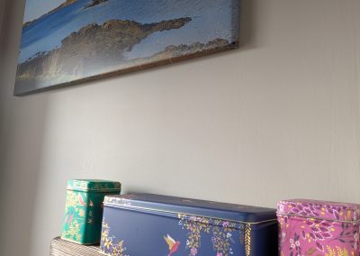Tins containing section of teas, coffee and hot chocolate on a burnt wood shelf